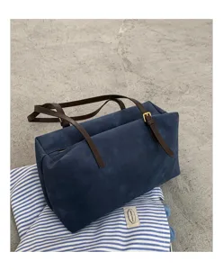 Dark blue suede retro pillow shoulder bag detail shot showing minimalist daily commuter tote style.