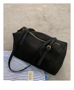 Detailed shot of black minimalist pillow shoulder bag, casual commuting tote bag closeup.