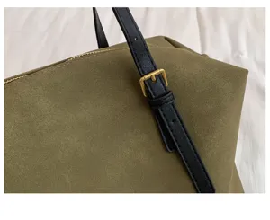 Close up detail view of olive green suede shoulder bag strap with gold buckle accent