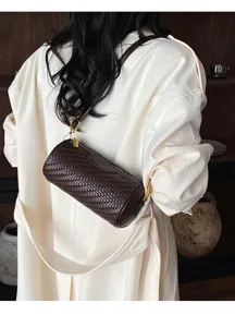 Detailed shot of retro dark brown woven cylindrical shoulder bag with elegant metal hardware.
