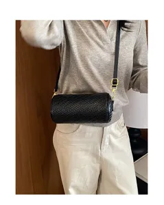 Womens black woven cylinder crossbody bag, stylish pillow shoulder bag with gold hardware.