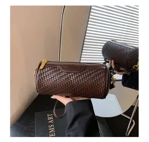Detailed view of vintage woven cylindrical shoulder bag, stylish dark brown barrel design.