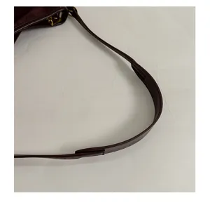 Detail shot of women's brown suede shoulder bag strap, minimalist and soft style.