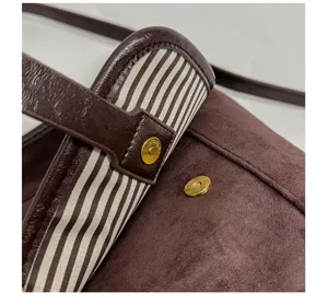 Brown suede women shoulder bag detail showing metal magnetic snap and striped lining.