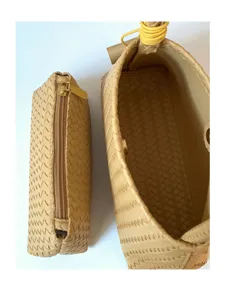 Beige woven handbag and matching pouch set with zip closure and chic strap details.