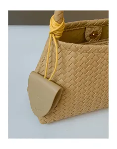 Woven leather handbag detail, beige shoulder bag texture, elegant fashion accessory close-up