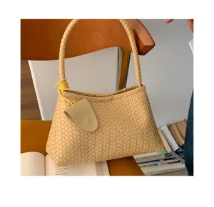 Detailed view of stylish beige woven shoulder bag, elegant underarm daily commuter purse.