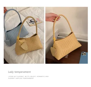Woven leather shoulder bag for women, stylish underarm commuter bag with chic design.
