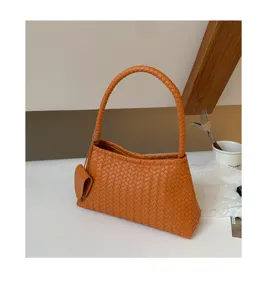 Orange woven shoulder bag detail showcasing premium leather texture and elegant knot design.