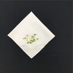 Nahaufnahme Detail eines weißen Baumwolltaschentuchs mit bunter Blumenstickerei und feiner Spitze.