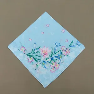 Vue détaillée du mouchoir en coton floral, avec un délicat motif imprimé de lys et fleurs.