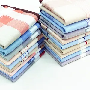 Close up view of stacked mens cotton plaid and striped handkerchiefs, soft textile detail.