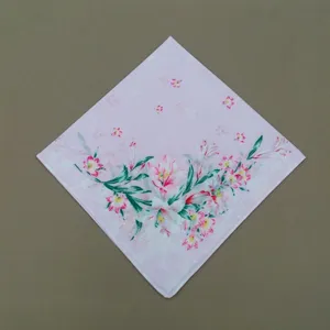 Vue détaillée du mouchoir en coton imprimé floral mettant en valeur un délicat motif de lys.
