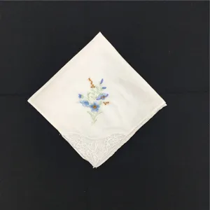 Detailansicht eines weißen Baumwoll-Stofftaschentuchs mit Blumenstickerei und Spitzenborte.