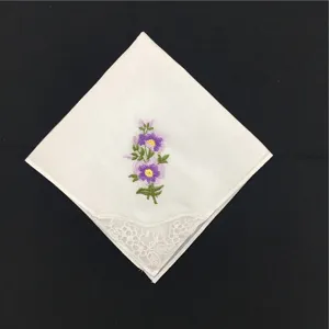 Nahaufnahme eines weißen Baumwolltaschentuchs mit lila Blumenstickerei und Spitzendetail.