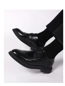 Scarpe stringate uomo in pelle nera brogue, dettaglio calzature eleganti da lavoro.