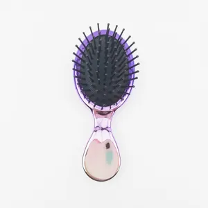 Détail de brosse à cheveux dégradée électroplaquée violette avec coussin d'air et épingles noires.