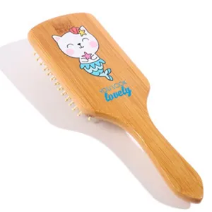 Vue détaillée de la brosse à cheveux en bambou avec motif chat mignon et coussin.