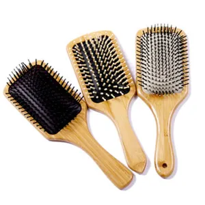 Brosse à cheveux plate en bois avec coussin d'air et picots massants pour le soin quotidien.
