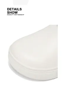 Close-up detail of men's white clog toe shoe, showing fine surface texture and sturdy build.