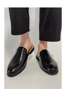 Detalle de mocasines slip-on negros de cuero para hombres, diseño informal muy cómodo.
