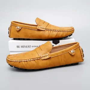 Detailed view of casual leather loafers in tan brown with contrast white stitching and sole.