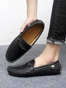 Close-up detail of black leather men loafers showcasing contrast stitching and slip-on design.