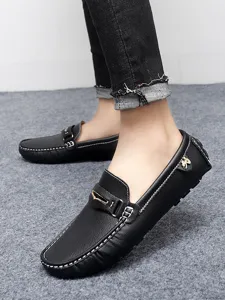 Close-up detail of mens black leather moccasins loafers with white stitching and metal buckle.