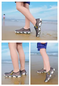 Detailansicht von Kinderschuhen mit atmungsaktivem Mesh und süßem Insekten-Design am Sandstrand.