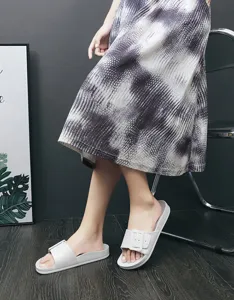 Close-up detail of grey women flat slippers sandals with square buckle summer footwear wear.