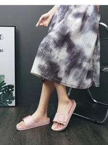 Comfortable pink slide sandals with decorative buckle detail, perfect for casual summer wear.