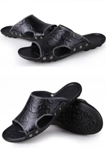 Vista detallada de sandalias de cuero negro para hombre con costuras y remaches metálicos.