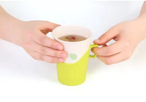 Dettaglio del portabicchieri usa e getta verde con manico e design antiscottatura.