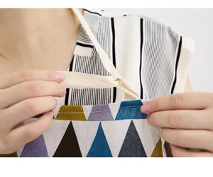 Close-up detail of the adjustable neck strap on a geometric triangle printed cotton linen apron.