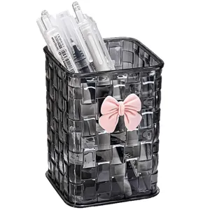 Transparent woven pen holder with pink bow for desktop cosmetic and stationery organization.