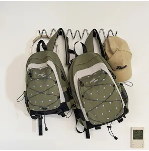 Green white contrast backpack with cute blue heart pattern, perfect for school and travel.