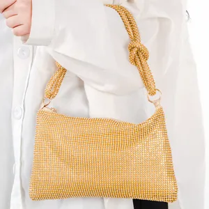 Gold rhinestone shoulder bag with chic knotted handle for elegant evening party wear.