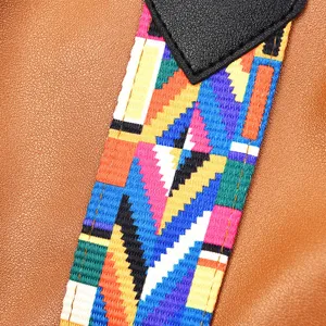 Detailweergave van damestas met kleurrijke etnische geometrische geweven band en leer.