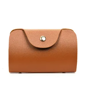 Kleine opbergtas van bruin leer, draagbare minimalistische hoes met drukknoopsluiting details.