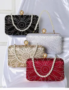 Elegant rhinestone evening clutch bag with pearl handle, sparkling floral design for women.