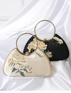 Bolso de noche bordado retro chino con motivo floral y detalle de asa de metal redondo.