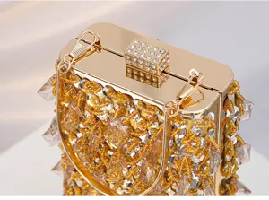 Close-up detail of luxury vintage beaded evening clutch bag, metallic gold clasp with rhinestones.