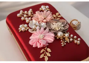 Bolso de noche tipo cartera de terciopelo rojo con flores de tela perlas y hojas de oro.