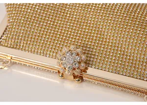 Exquisite rhinestone evening clutch bag detail, gold metal frame with sparkling crystal flower.