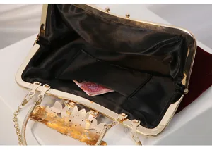 Red velvet evening clutch bag interior detail, gold metal frame and delicate vintage clasp.
