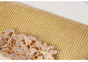 Close-up detail of luxury rhinestone evening clutch bag with sparkling crystal leaf clasp.