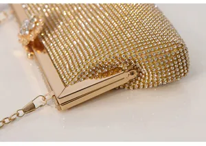 Detailed view of luxury rhinestone evening clutch bag with sparkling crystals and gold metal frame.