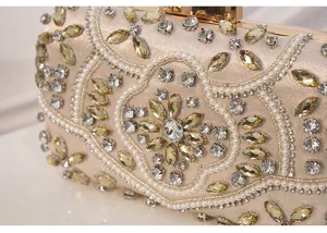 Detail view of a vintage beaded rhinestone evening clutch bag with pearls and gold clasp.