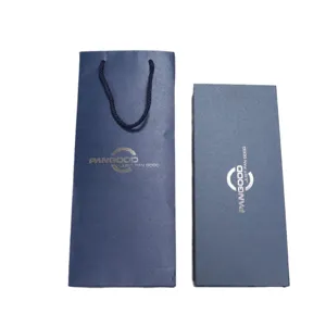 Vue détaillée du sac cadeau en papier spécial bleu foncé de luxe et de son coffret pour cravate.
