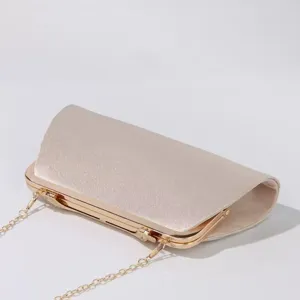 Elegante champagnerfarbene Abendtasche mit goldenem Metallrahmen und feiner Kette.
